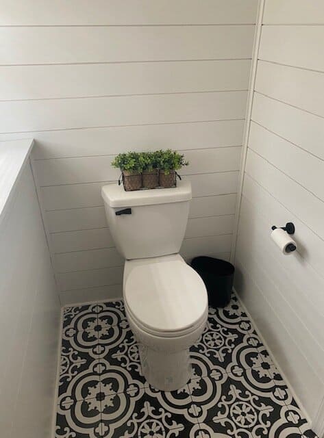 installed toilet plumbing fixture in a modern black and white bathroom.