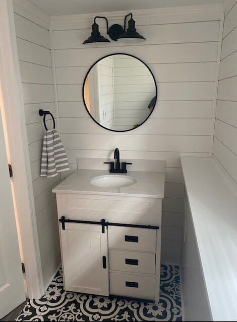 bathroom sink, faucet and vanity installed in a modern black and white bathroom.