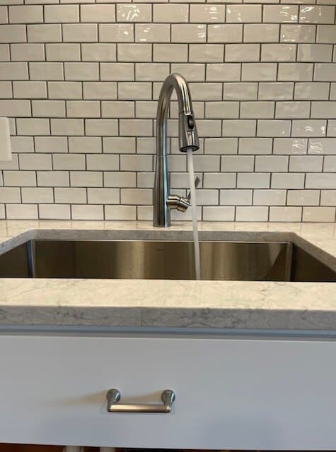 recently installed stainless steel kitchen sink and faucet.